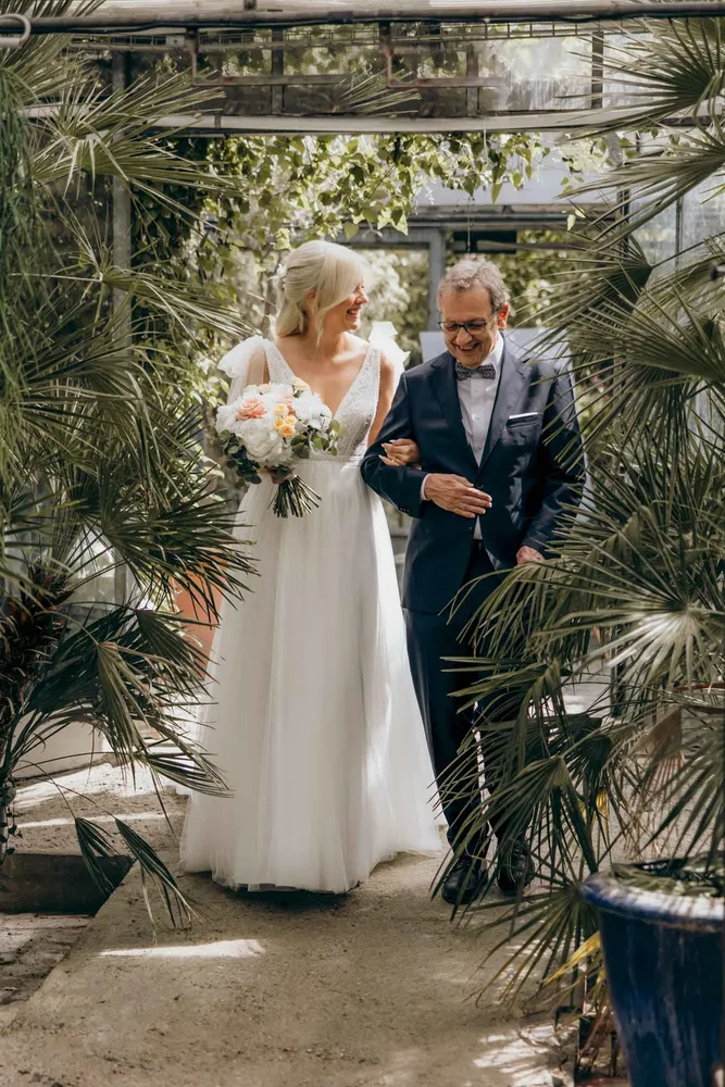 Braut im weißen Kleid mit Brautstrauß zusammen mit einem Mann bei der Hochzeit