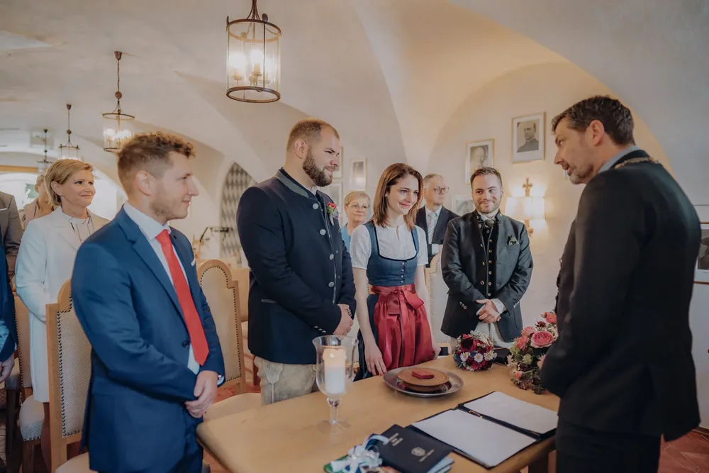 Brautpaar am Flussufer vor gelbem Gebäude bei einer standesamtlichen Hochzeit in der Tegernsee-Region