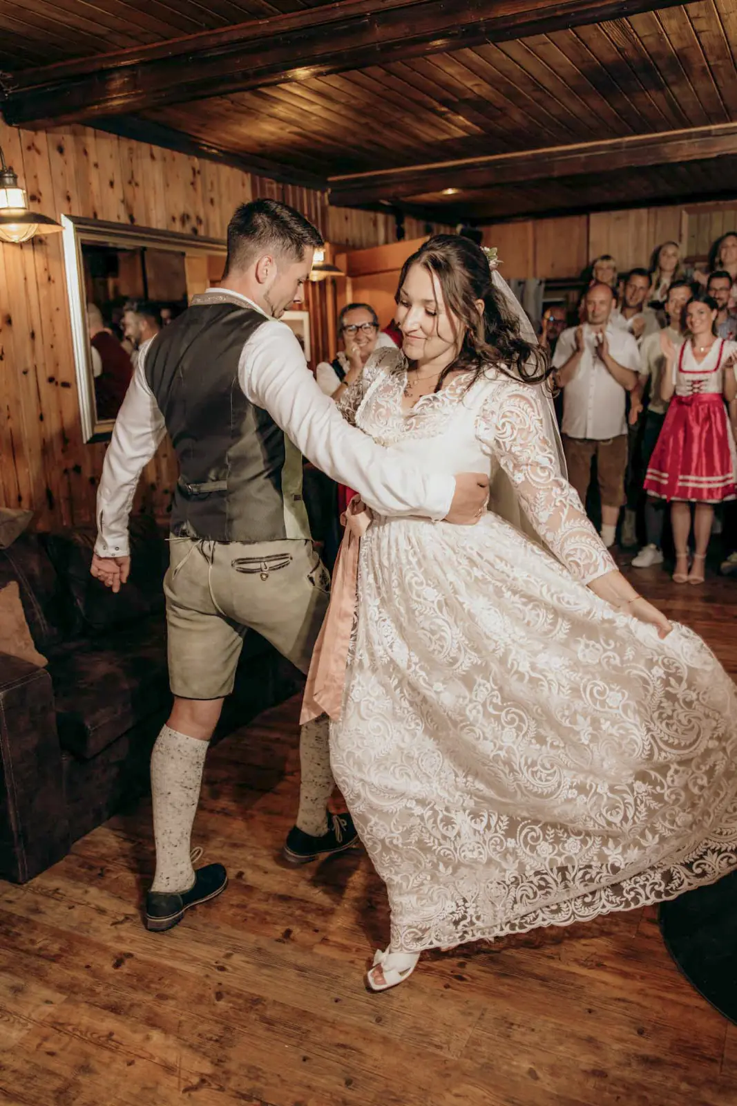 Hochzeitstanz in der holzvertäfelten Stube, die Gäste stehen im Kreis darum