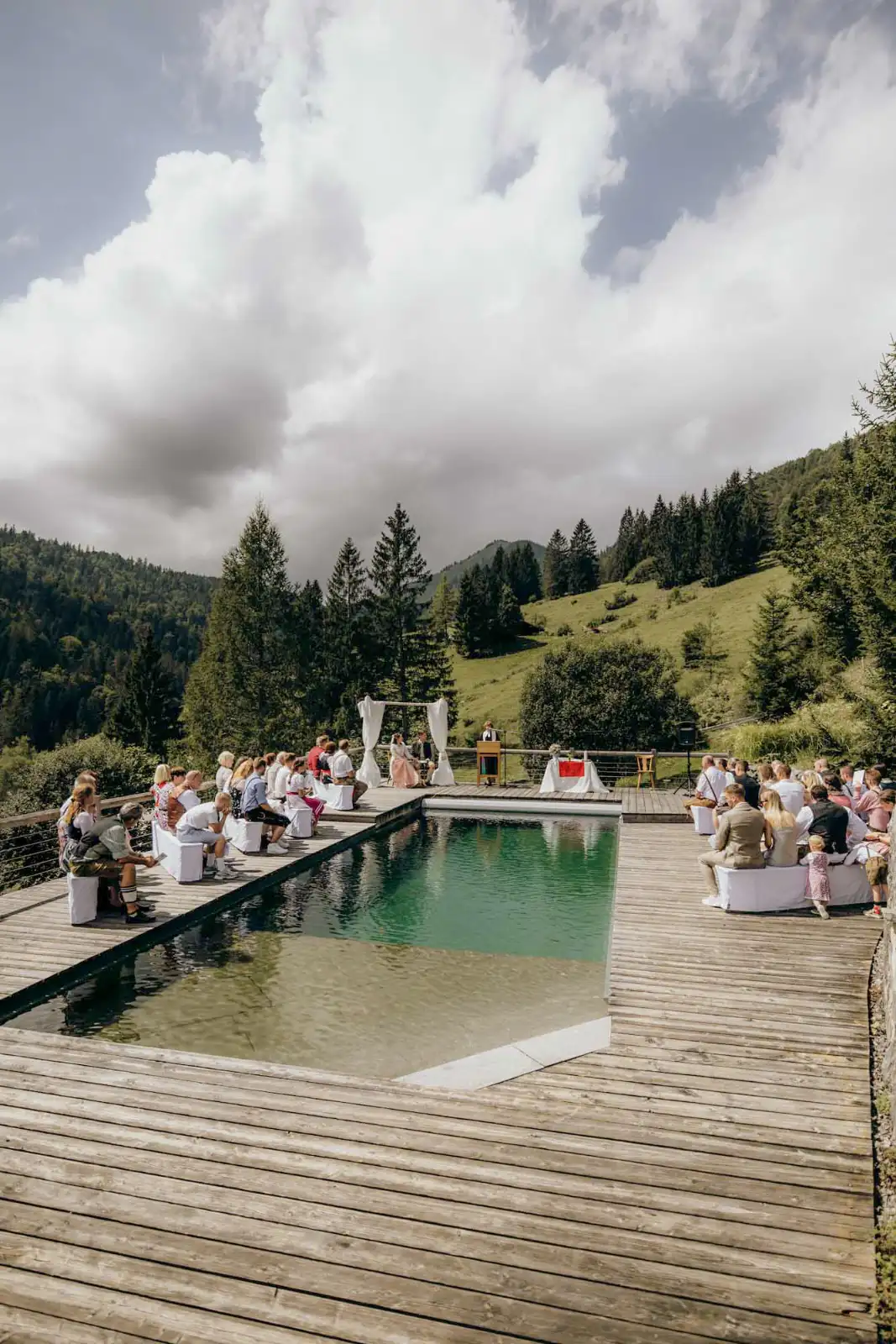 Freie Trauung auf der Holzterrasse am Natur-Pool des Almbad Sillberghaus, die Gäste sitzen rundherum
