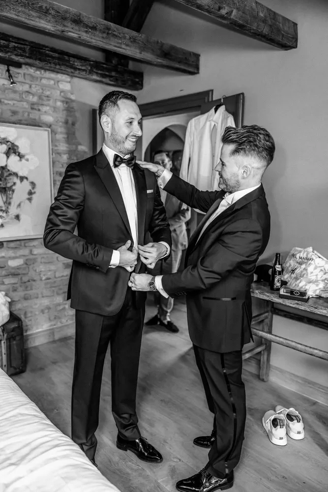 Zwei Männer in Smokings helfen sich beim Anziehen beim Getting Ready